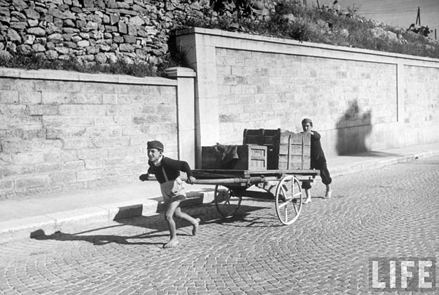 Boy wearing rope harness pulls a cart along highroad outside Bari (Мальчик, тянущий телегу по дороге около Бари), 1947