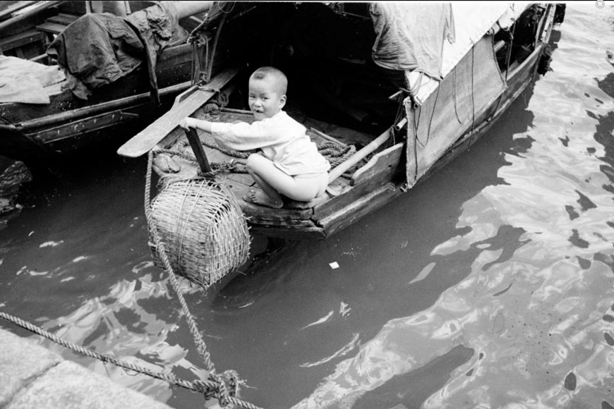 Little boy relieving himself off docked houseboat (Мальчик, испражняющийся со своего дома на воде), 1940s