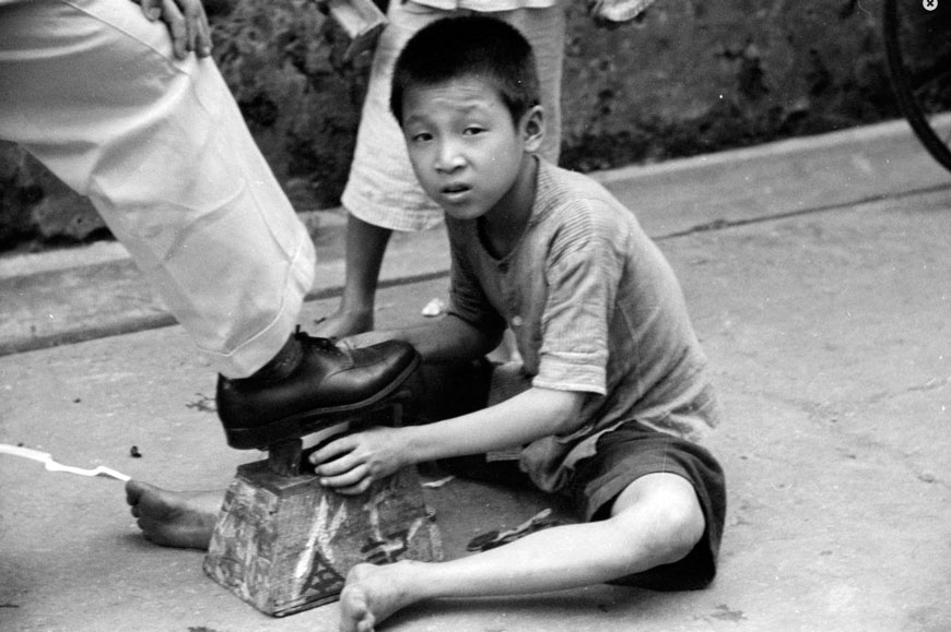 Boy shining man's shoe on sidewalk (Мальчик, чистящий обувь мужчине на тротуаре), c.1941