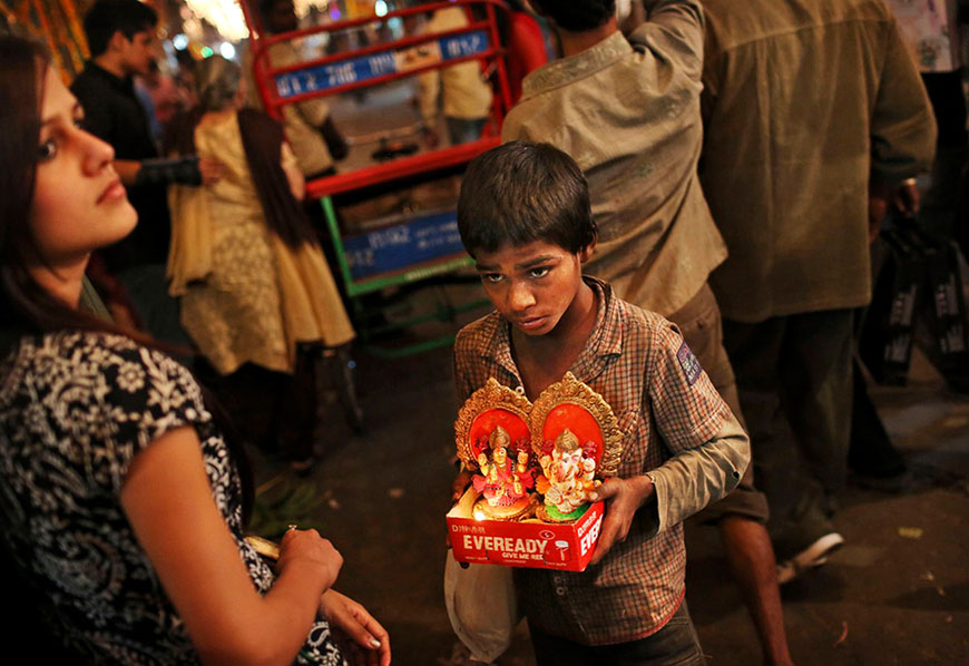 A young Indian boy sells small deities of the goddess Lakshmi and the god Ganesha during the festival of Diwali (Мальчик продает маленьких божков - богиню Лакшми и бога Ганеши), Nov.13.2012