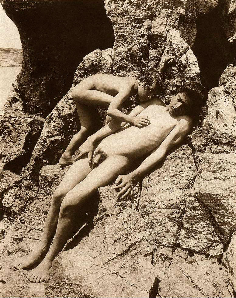 #1545, Zwei an eine Felswand gelehnte Jungen, im Hintergrund das Meer, 1900s