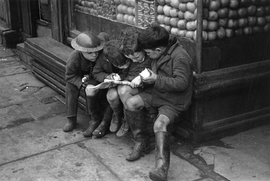 A boy in a tin hat hangs out with his friends outside a shop (Мальчик в жестяной каске с друзьями у магазина), 1940