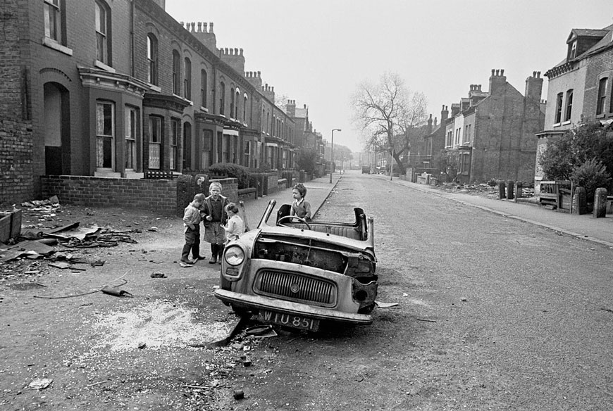 Children play on a ruined car in the street (Дети, играющие на улице у разрушенной машины), 1970