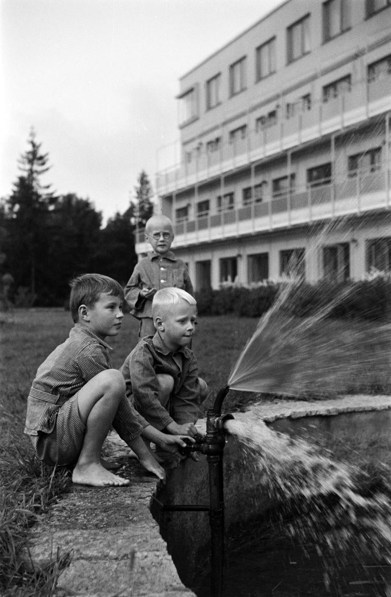 Kaksi poikaa leikkimässä vedellä Lastenklinikan pihalla (Два мальчика, играющие с водой во дворе детской поликлиники), 1949