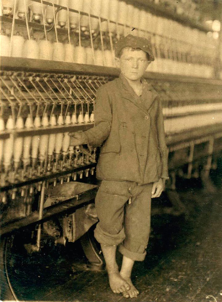 Young doffer boy at machine in Massachusetts Mills (Мальчик у станка на фабрике Массачусетс-Миллс), 1913