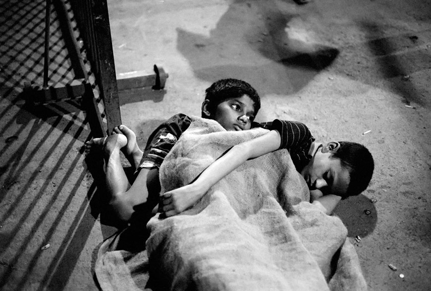 Street children Gangaram and Annu, about to fall asleep at the Victoria Terminus Station near a railtrack