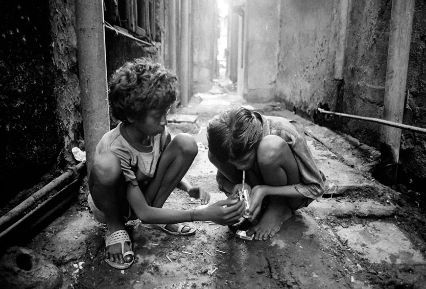 Fiorze and Sadik smoke 'brown sugar' (heroin) in alley in the red light district of Kamatipura