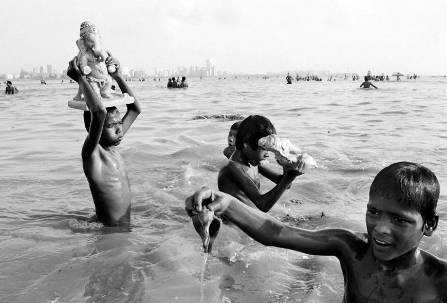 Street children from the VT gang immersing a statue of the Hindu God Ganesh into the sea during the annual Gampati Festival at Chowpatti beach