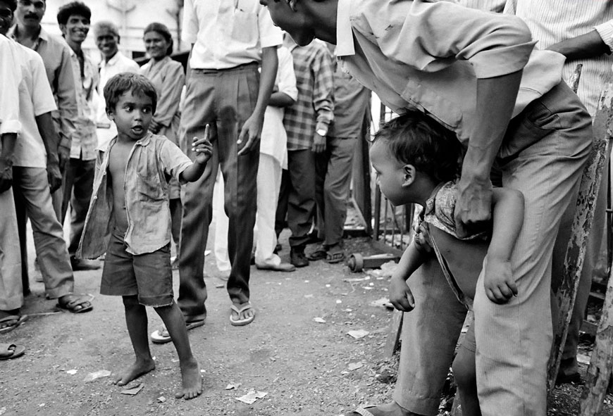 Suresh, 6 years old and Ramesh, 5 years old, are dragged apart by an amused crowd during a fight outside Amchi Kholi Centre for street children at VT