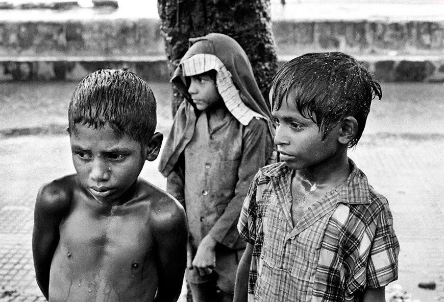 Street children sheltering from the monsoon rain on Chowpatti beach