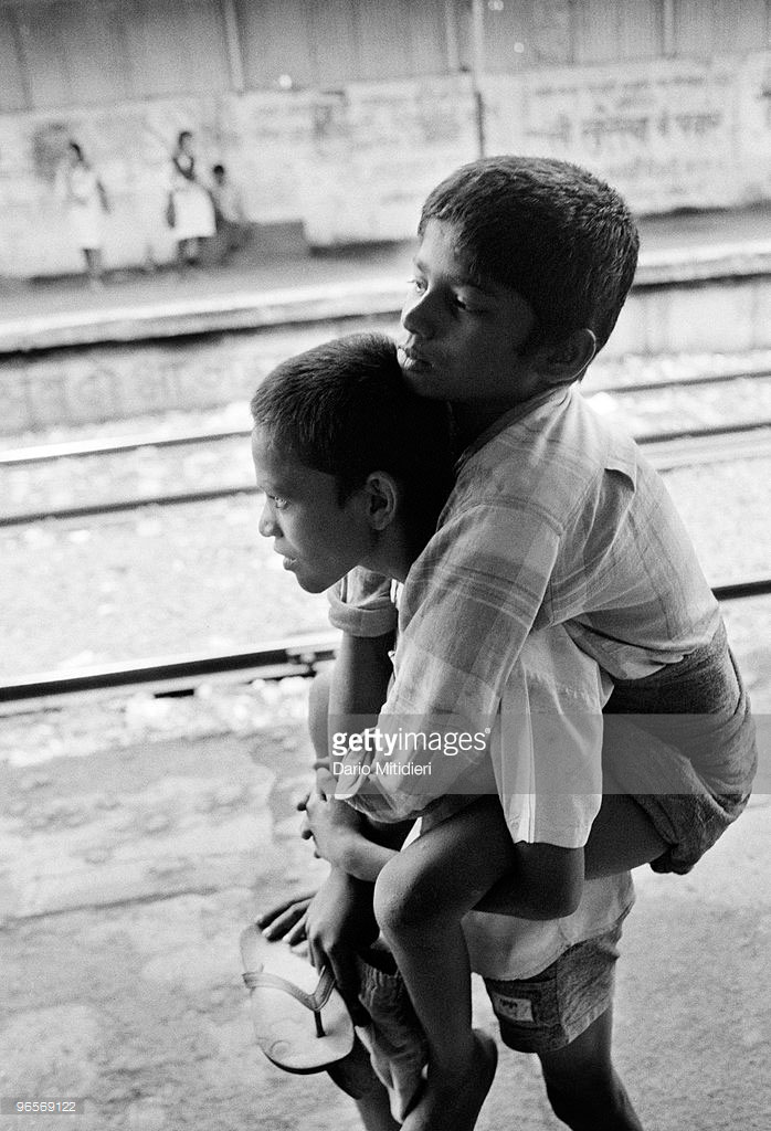 Street child Annu carrying his friend Gangaram who suffers from polio, at Victoria Terminus Station