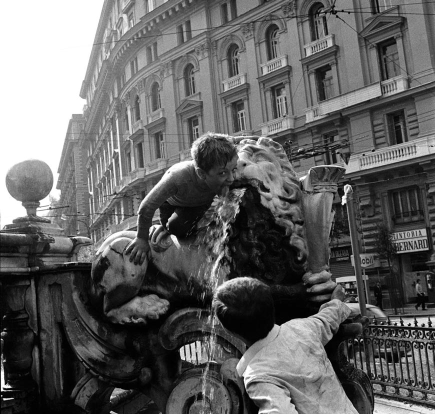 Two Little boys drinking from a lion's mouth. The lions ring the central monument of the Neptune Fountain (Два мальчика пьют изо рта льва. Львы окружают центральный монумент фонтана Нептуна.), 1970