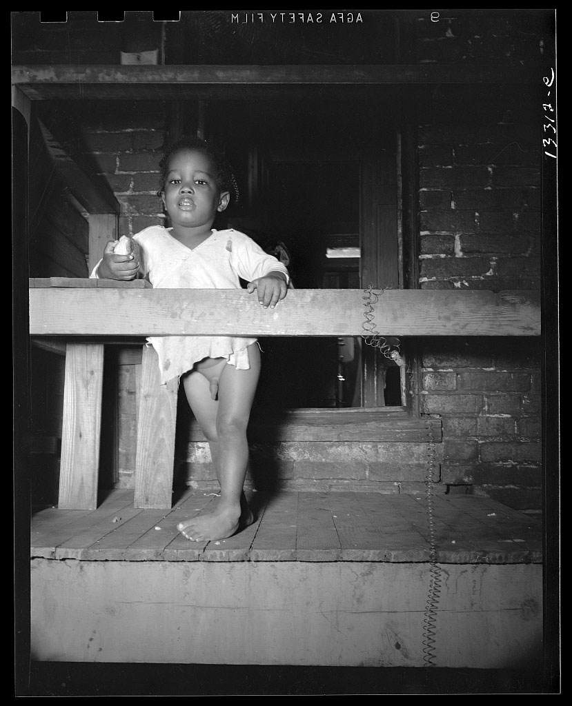 Child playing on the front porch of her home (Ребёнок, играющий на крыльце своего дома), June 1942