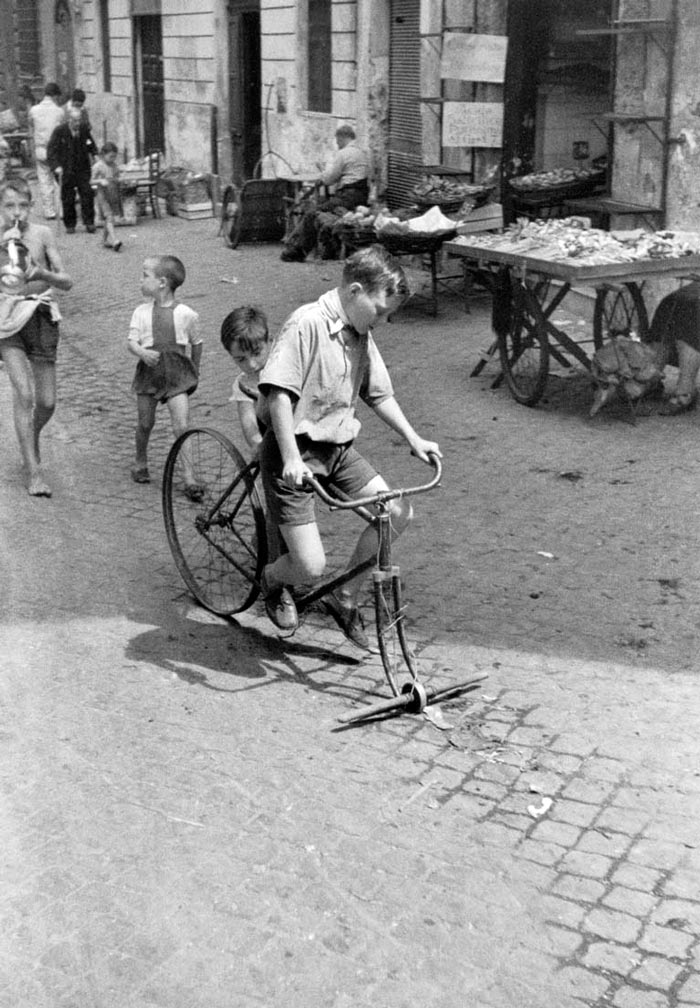 Bambini giocano con bicicletta rotta lunga la strada (Дети играют со сломанным велосипедом на дороге), 1945