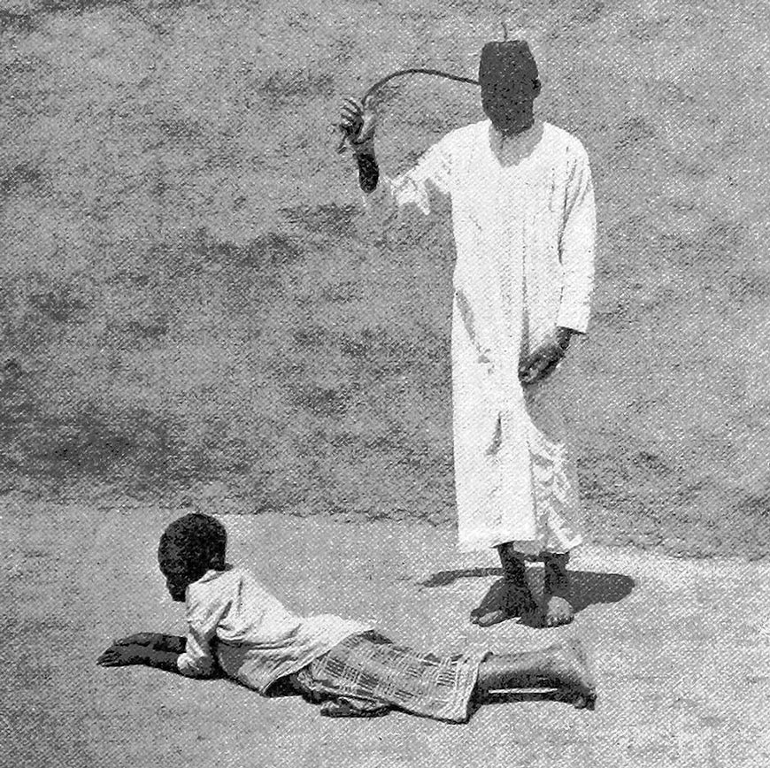 Schoolmaster correcting one of his pupils using the traditional hippo-hide kiboko (Школьный учитель наказывает одного из своих учеников традиционным кибоко из кожи гиппопотама), 1940s