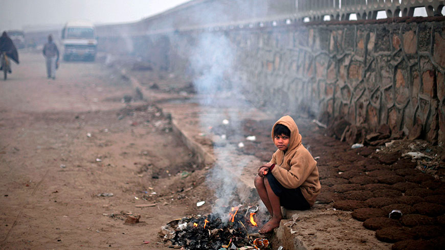 A boy keeps himself warm near burning trash on a cold morning (Греющийся холодным утром у горящего мусора мальчик), 2012