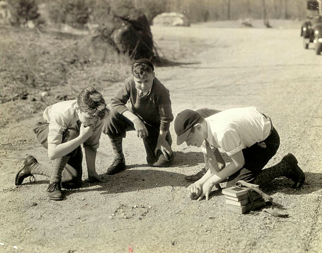 Young School Boys Playing Marbles in a Crucial Moment on Dirt Road (Юные школьники, играющие в марбл в решающий момент на грязной дороге), June 14, 1926