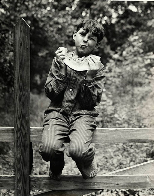 Boy Eating Watermelon While Sitting on a Fence (Мальчик, поедающий арбуз, сидя на заборе)