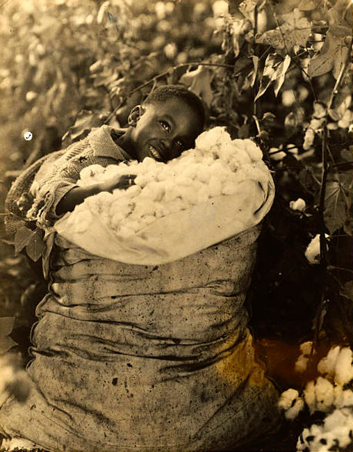 Boy Resting in Cotton Bag with a Winning Smile (Мальчик с победной улыбкой, отдыхающий на мешке с хлопком)