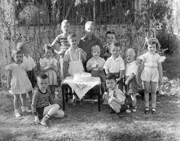 Group portrait of children at outdoor birthday party with cake (Групповой портрет детей с тортом на праздновании дня рождения), c.1950