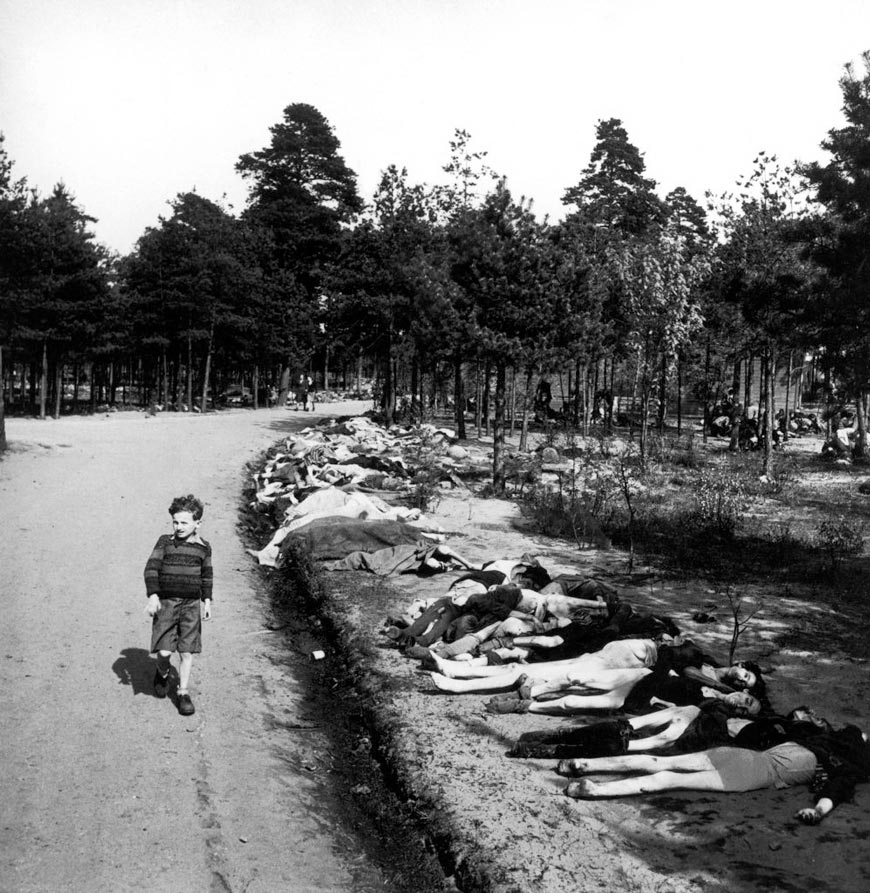 A boy walks by corpses at the Bergen-Belsen concentration camp (Мальчик проходит мимо трупов в концентрационном лагере Берген-Бельзен), 1945