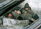 Homeless children sleep in a trash bin