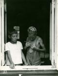 Portrait of two boys standing at open window