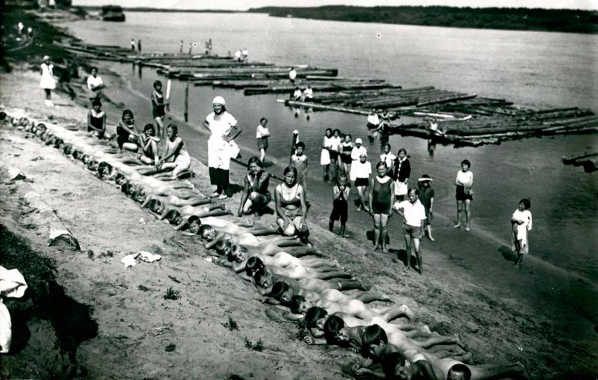 Пионеры принимают солнечные ванны на берегу реки Шексна (Pioneers sunbathing on the banks of the Sheksna River), 1935