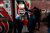 Boys buy Pepsi from a vending machine
