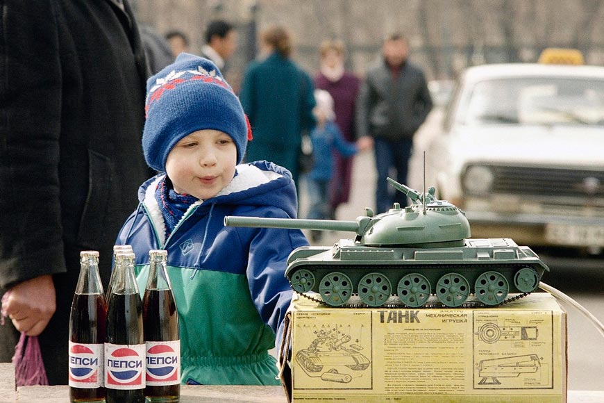 Мальчик смотрит на модель танка и бутылки пепси российского производства (A boy looks at a model of a tank and bottles of Russian-made Pepsi) 29 марта 1992 