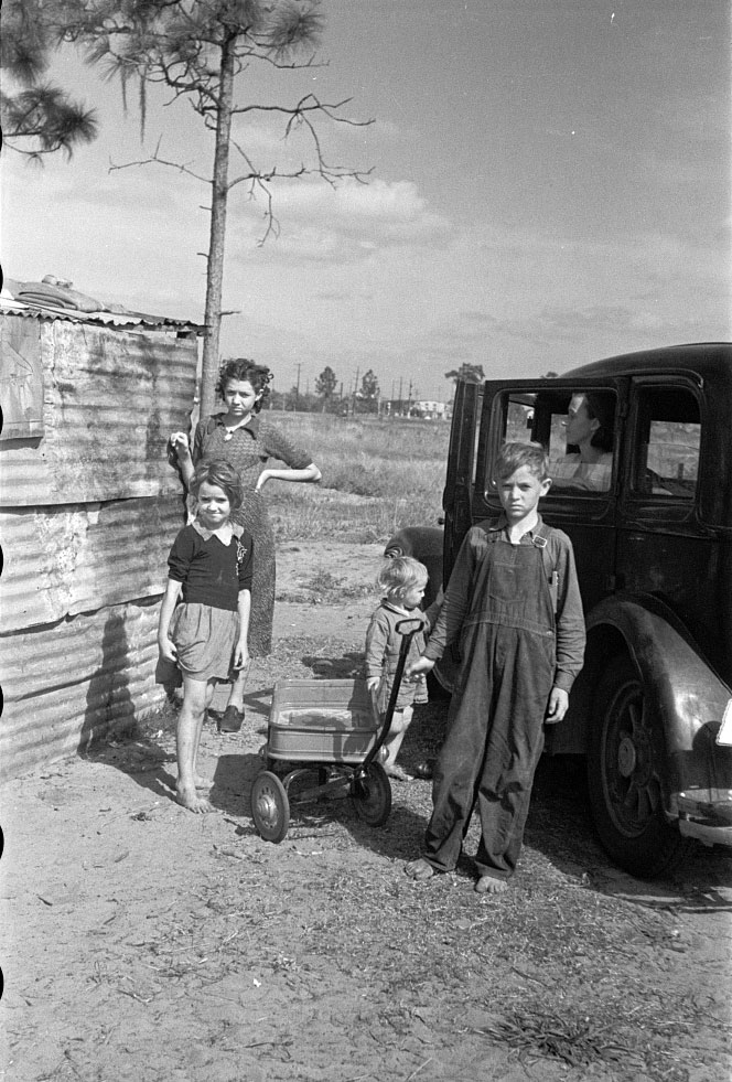 Part of the family of a migrant fruit worker from Tennessee, camped near the packinghouse (Часть семьи мигрирующего сборщика фруктов из Теннесси, живущая рядом со складом), Jan.1937