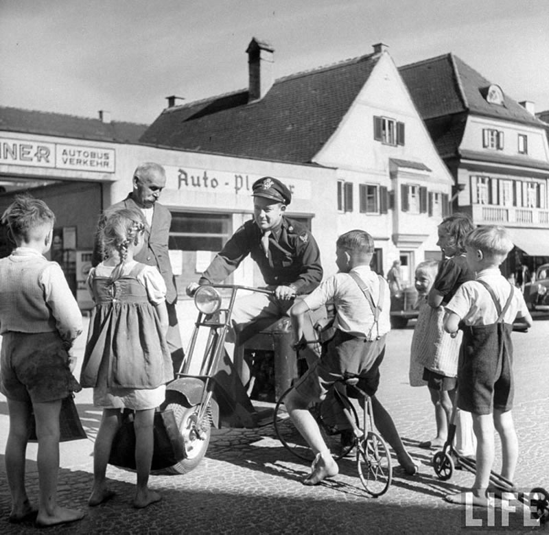 Jet pilot on motor scooter stopping to talk with children (Мотоциклист, разговаривающий с детьми), September 1946