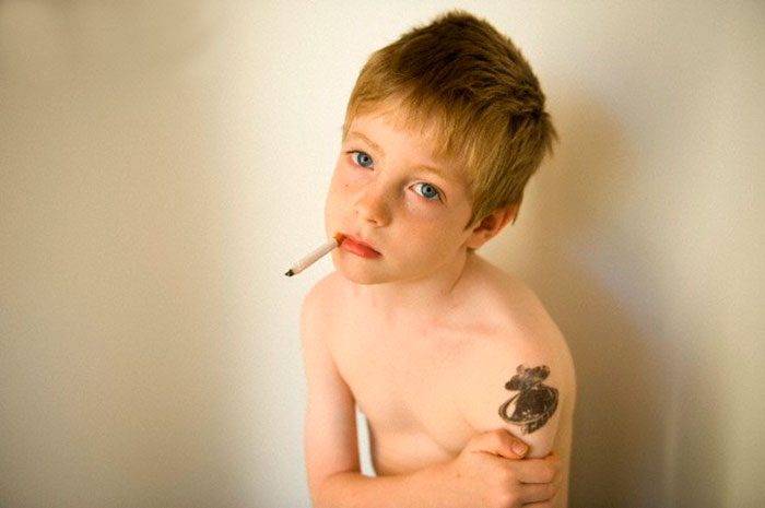 A young boy pretending to smoke gum cigarrettes at his home (Мальчик, изображающий курение сигареты), 2006 