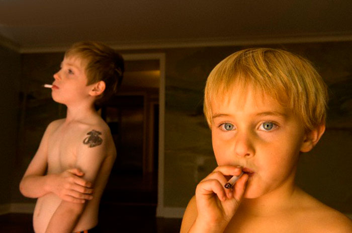 A young boy pretending to smoke gum cigarrettes at his home (Мальчик, изображающий курение сигареты), 2006 