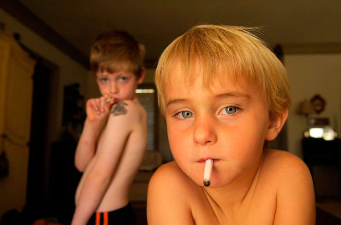 A young boy pretending to smoke gum cigarrettes at his home (Мальчик, изображающий курение сигареты), 2006 