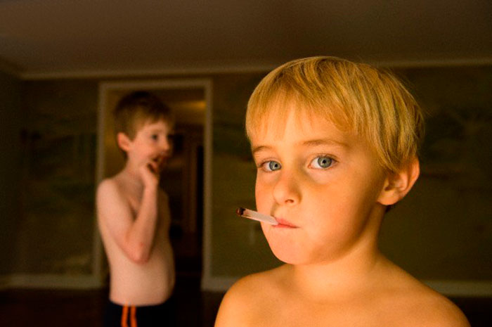 A young boy pretending to smoke gum cigarrettes at his home (Мальчик, изображающий курение сигареты), 2006 