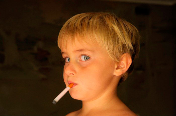 A young boy pretending to smoke gum cigarrettes at his home (Мальчик, изображающий курение сигареты), 2006 