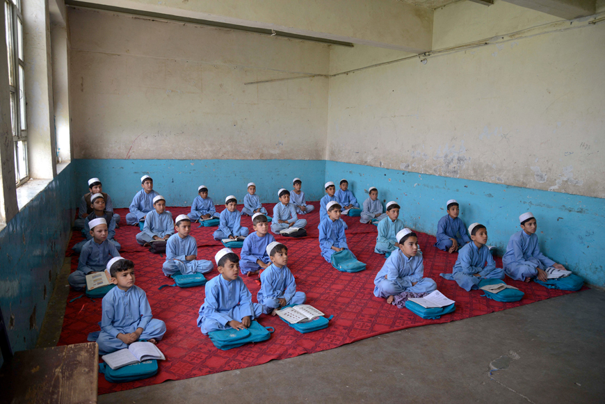 Afghan junior schoolboys, wearing salwar kameez and white hats as part of a new uniform code, attend class at a high school (Афганские школьники младших классов, одетые в сальвар-камизы и белые шапки в соответствии с новой формой одежды, на занятия в средней школе), 2025