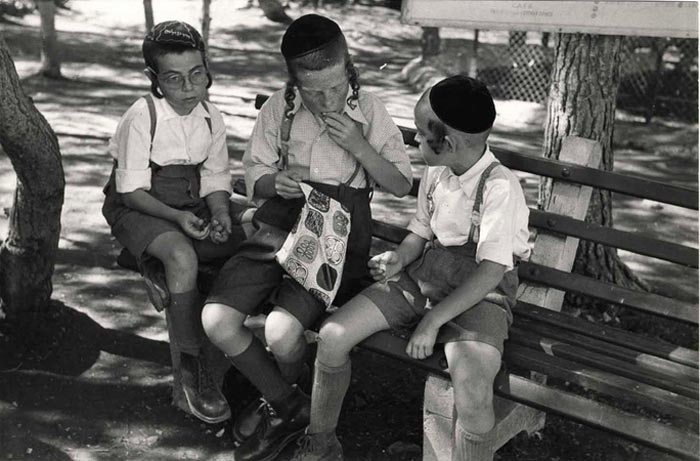 Three young religious boys sitting on a bench eating (Три мальчика-ортодокса сидят на скамейке и едят), 1954