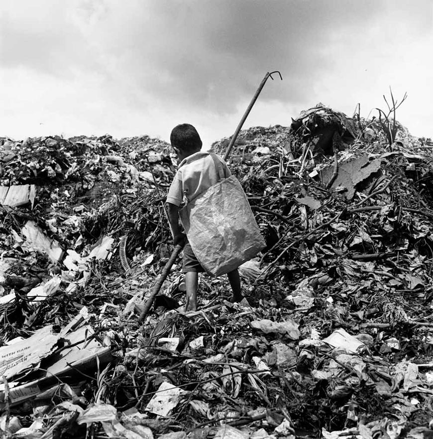 Boy scavenging trash for plastic and metal recyclables (Мальчик собирает мусор для вторичной переработки) 