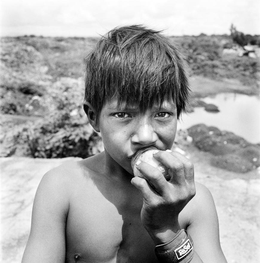 Boy sniffing a bottle of glue by trash dump (Мальчик нюхает бутылку из-под клея на свалке)