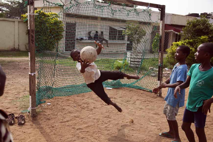 Community team from Sakumono Estate play in the mornings on a rough pitch. After their game is over local children play there too, 2010