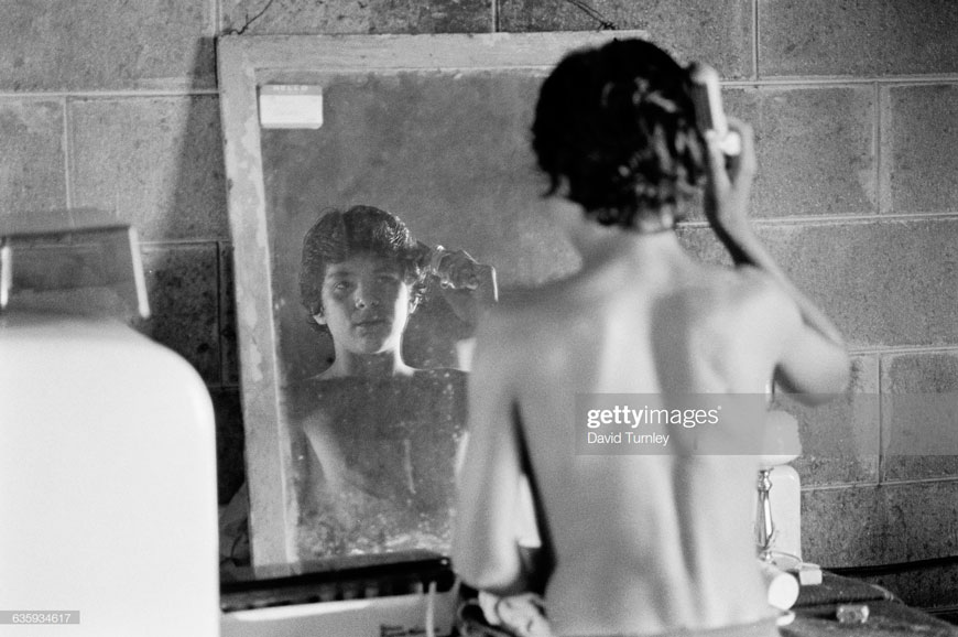 A young boy of a farm worker family combs his hair at home (Мальчик из семьи работников фермы расчёсывает волосы), 1990s