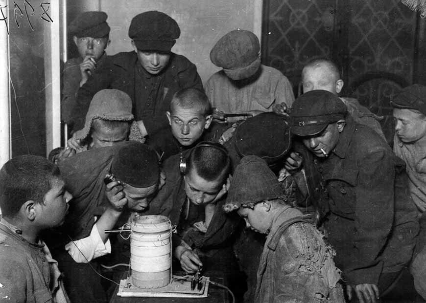 Беспризорники в общежитии у приемника слушают радио (Homeless children in the dormitory listening to the radio), 1925