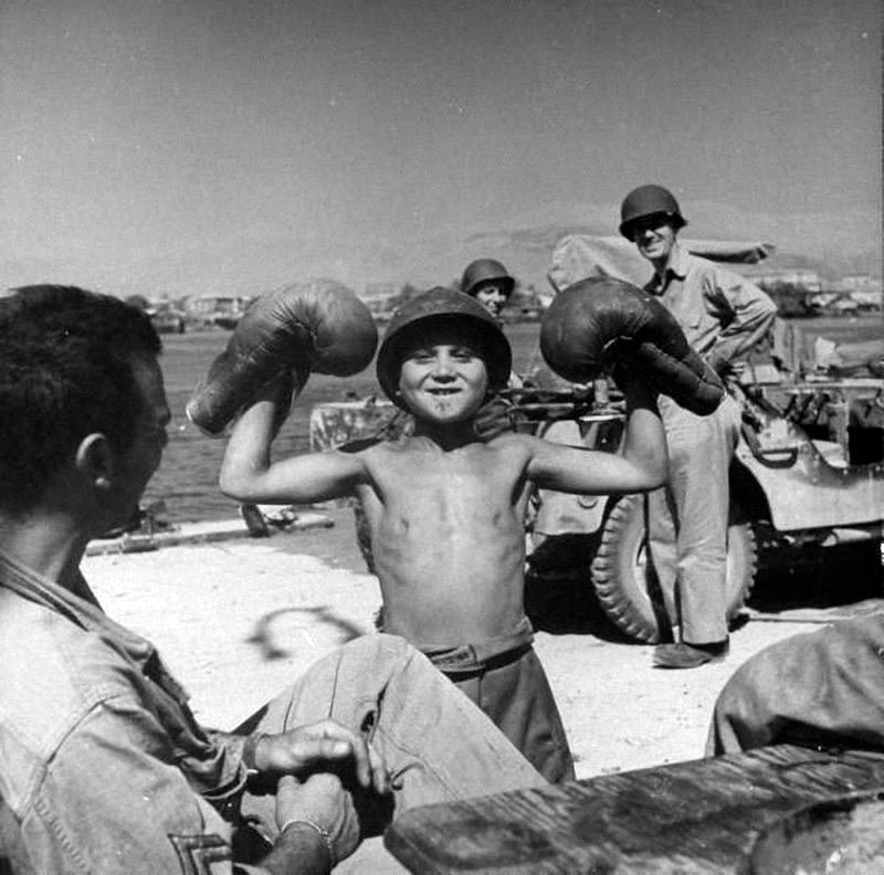 American sailors taking delight in young Sicilian boy's imitation of Mussolini (Американские моряки восхищаются, как сицилийский мальчик имитирует Муссолини), 1943