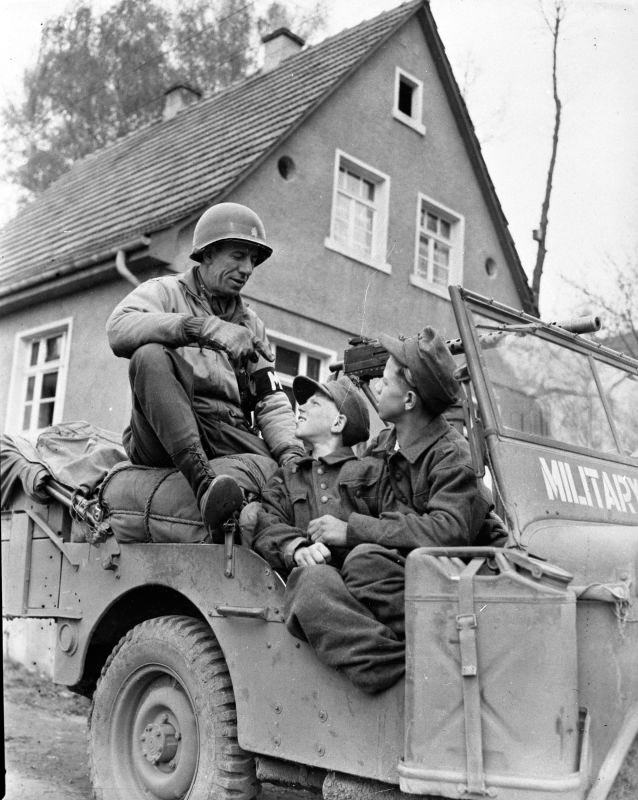 Major of the Military Police of the 11th Armored Division of the US with German teenage soldiers captured in the Kulmbach (Майор военной полиции 11-й бронетанковой дивизии США с немецкими солдатами-подростками, взятыми в плен в районе Кульмбаха), April 1945