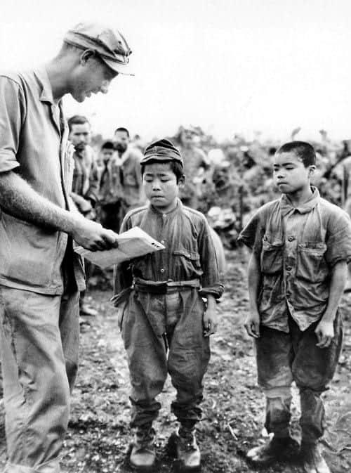 U.S. Marine 1st Lt. Hart H. Spiegel tries to communicate with two Japanese child soldiers captured during the Battle of Okinawa (Первый лейтенант морской пехоты США Харт Х. Шпигель пытается поговорить с двумя японскими детьми-солдатами, захваченными во время битвы за Окинаву), 17 June 1945