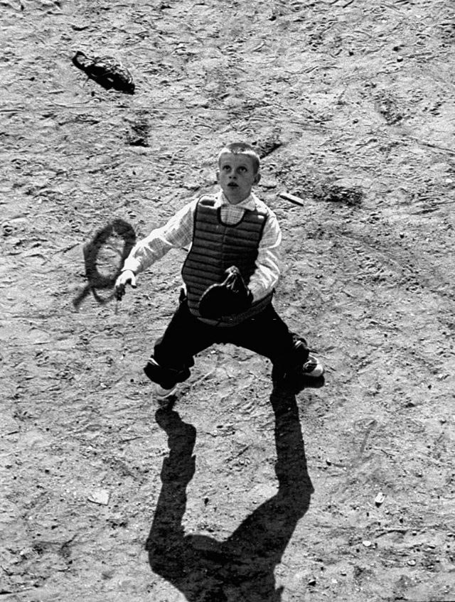 A boy playing catcher during a Little League baseball game (Мальчик ловит мяч во время бейсбольной игры Малой лиги), 1954