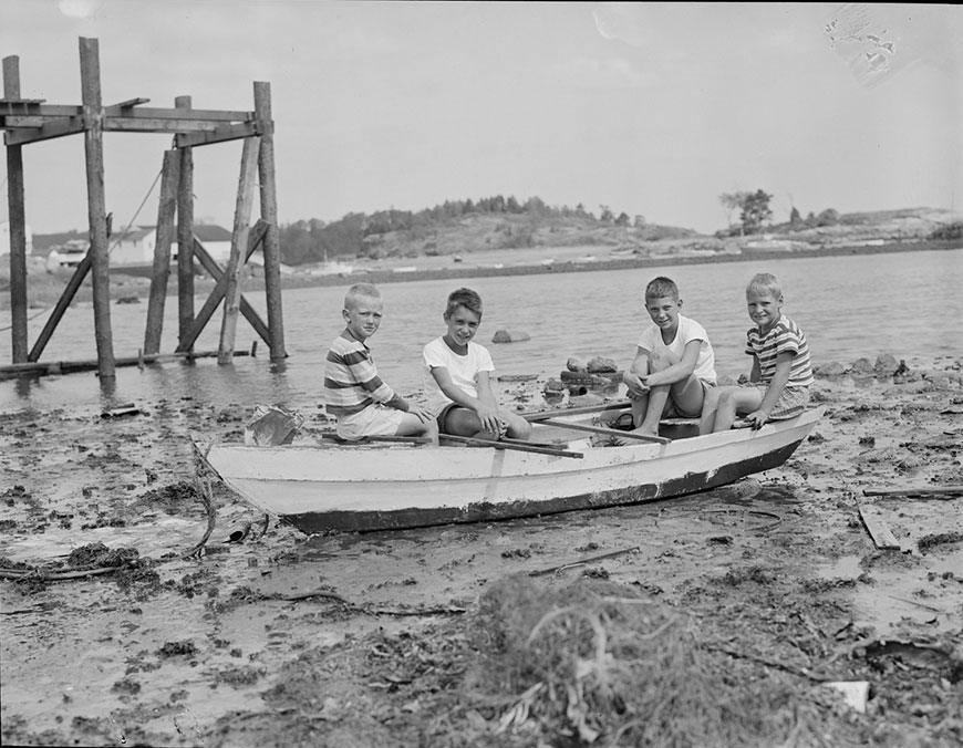 Boys sit in boat amid debris from hurricane (Мальчишки, сидящие в лодке на фоне разрушений от урагана), 1954 