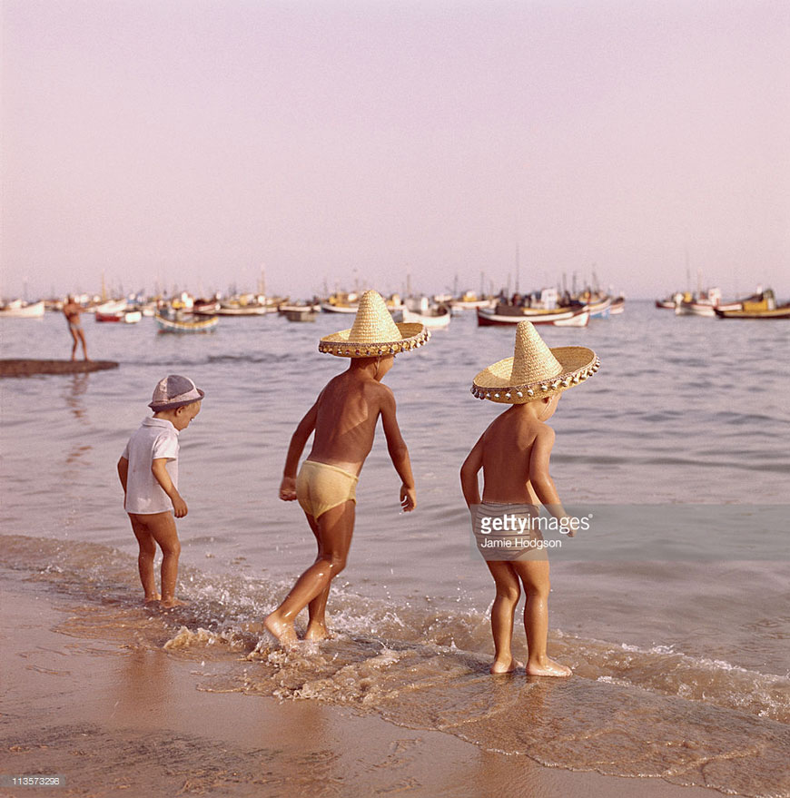 Three little boys brave the sea together on holiday (Три мальчика храбро вступают в океан на каникулах), c.1970